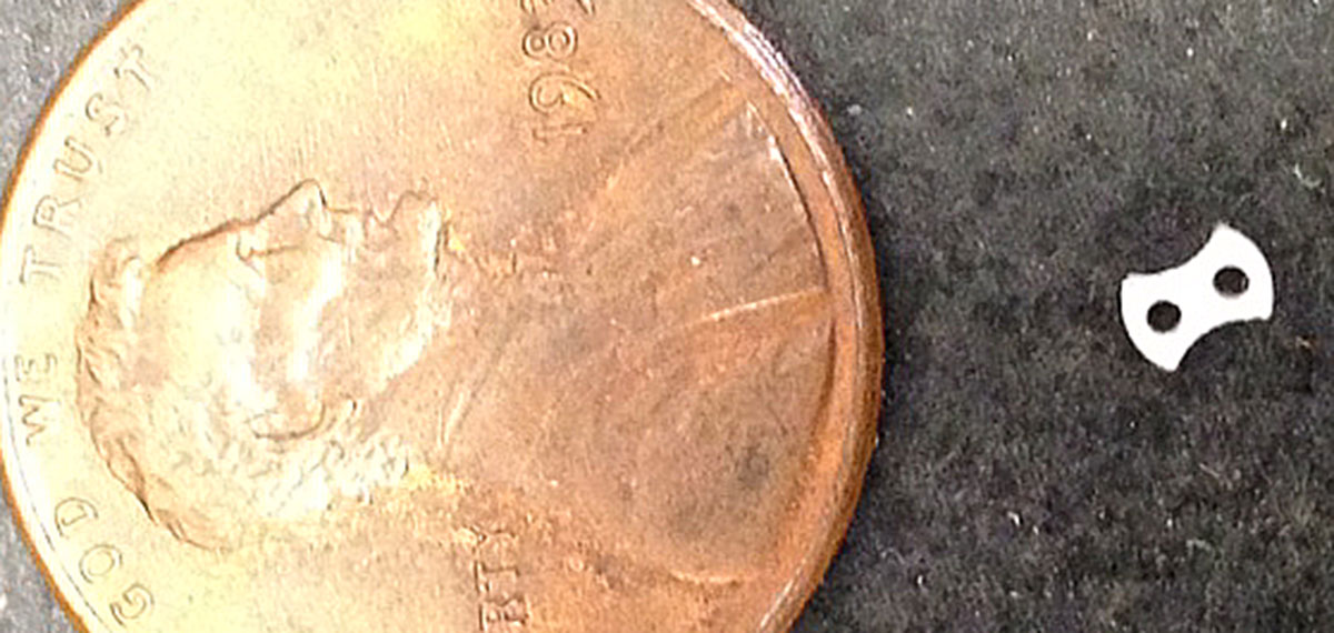 CRG Precision Machine miniature precision machining next to a penny